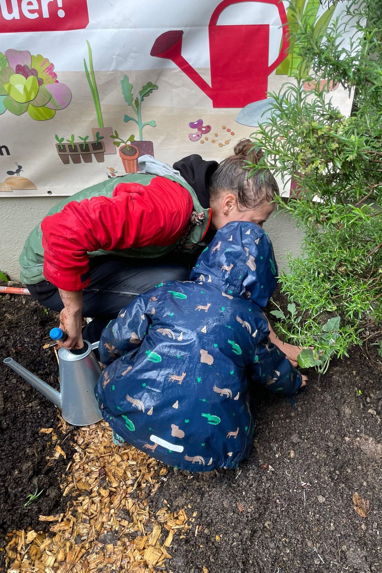 Kita kidsco Kreis 7 Kind lernt im Garten mit Hilfe der Betreuerin