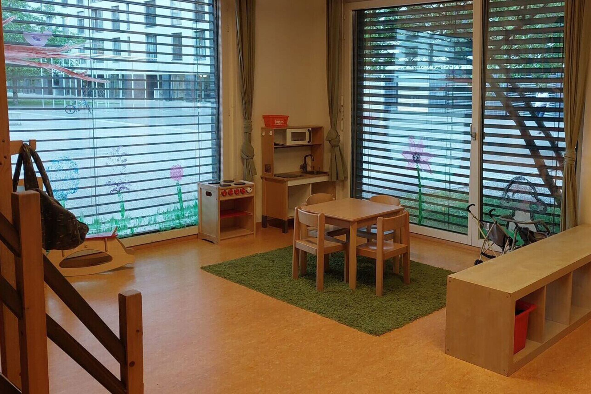 Kita kidsco Binzallee Kitaraum mit zwei Fensterfronten und Holzmobiliar