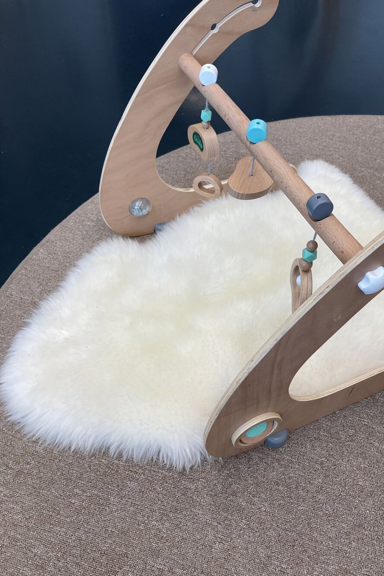 Kita kidsco Campus PH ZH Babymobile aus Holz mit Fellunterlage