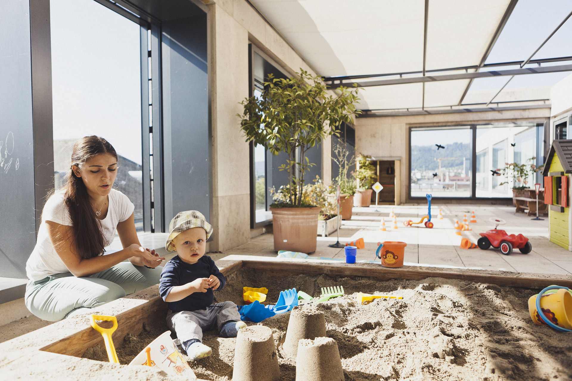 Kita kidsco Campus PH ZH Betreuerin spielt mit einem Kind im Indoor Sandkasten der Kita