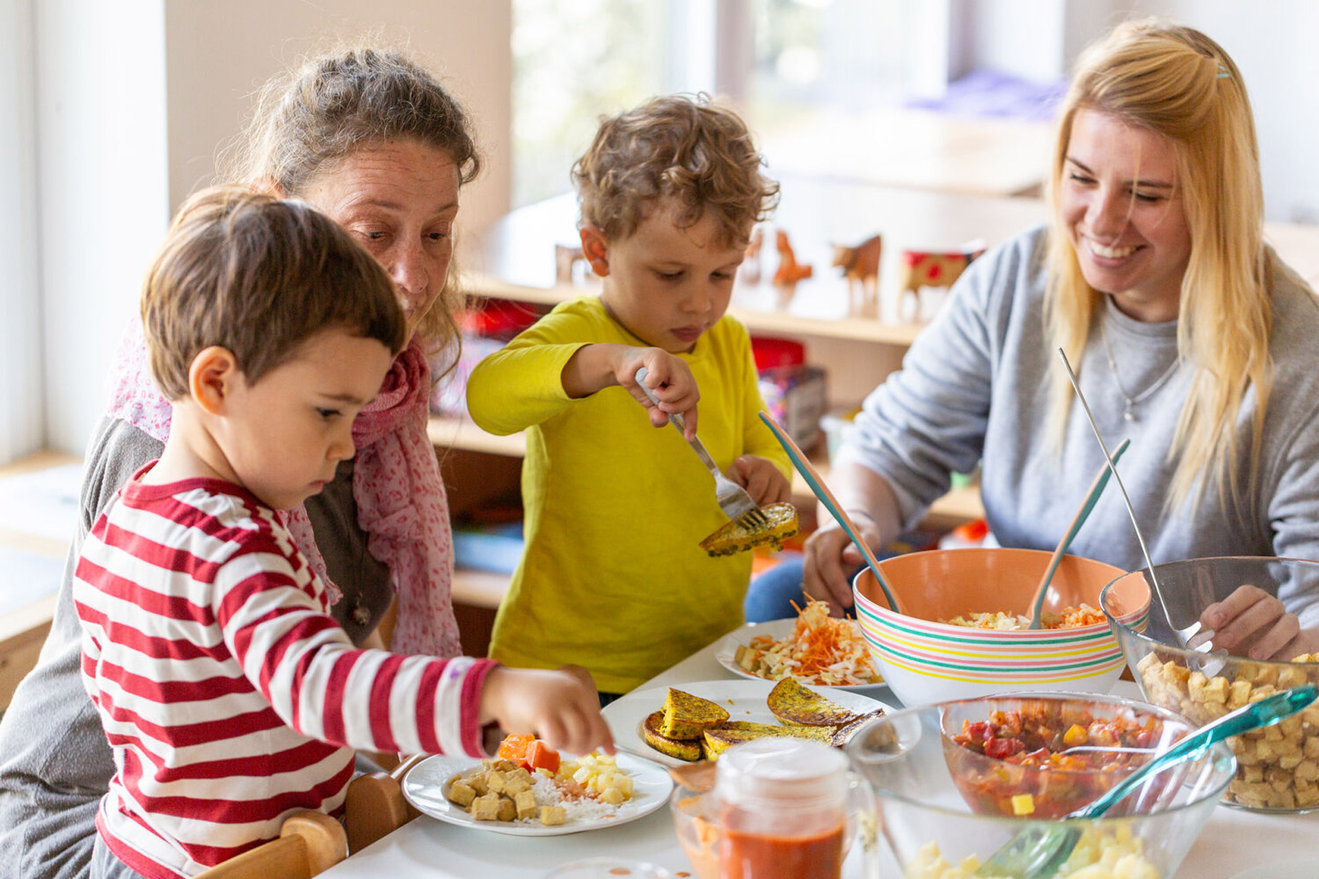Kita kidsco City Kinder bei einer gemeinsamen Mahlzeit mit den Betreuerinnen