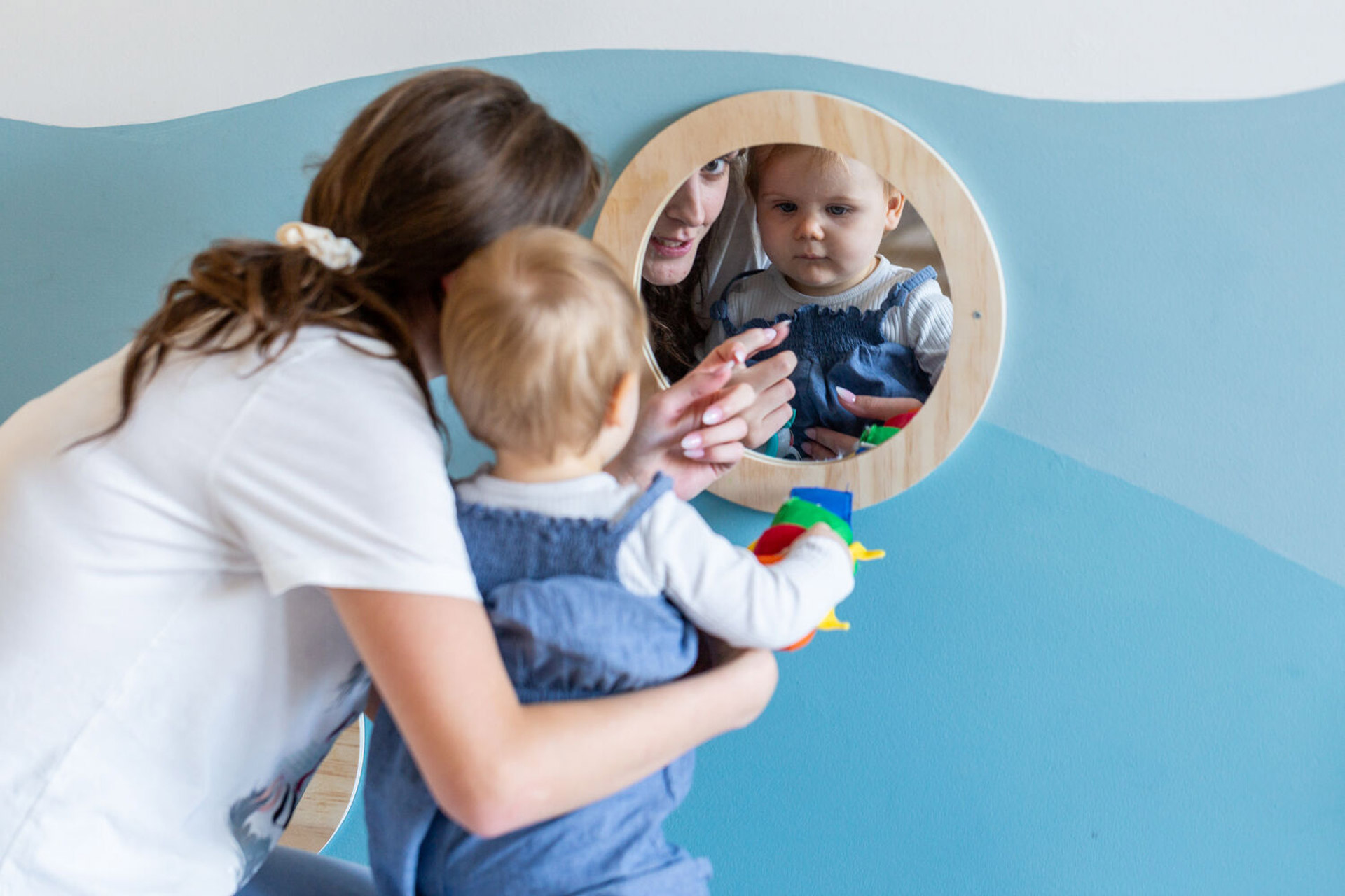 Kita kidsco City Kind und Betreuerin beachten sich im Spiegel
