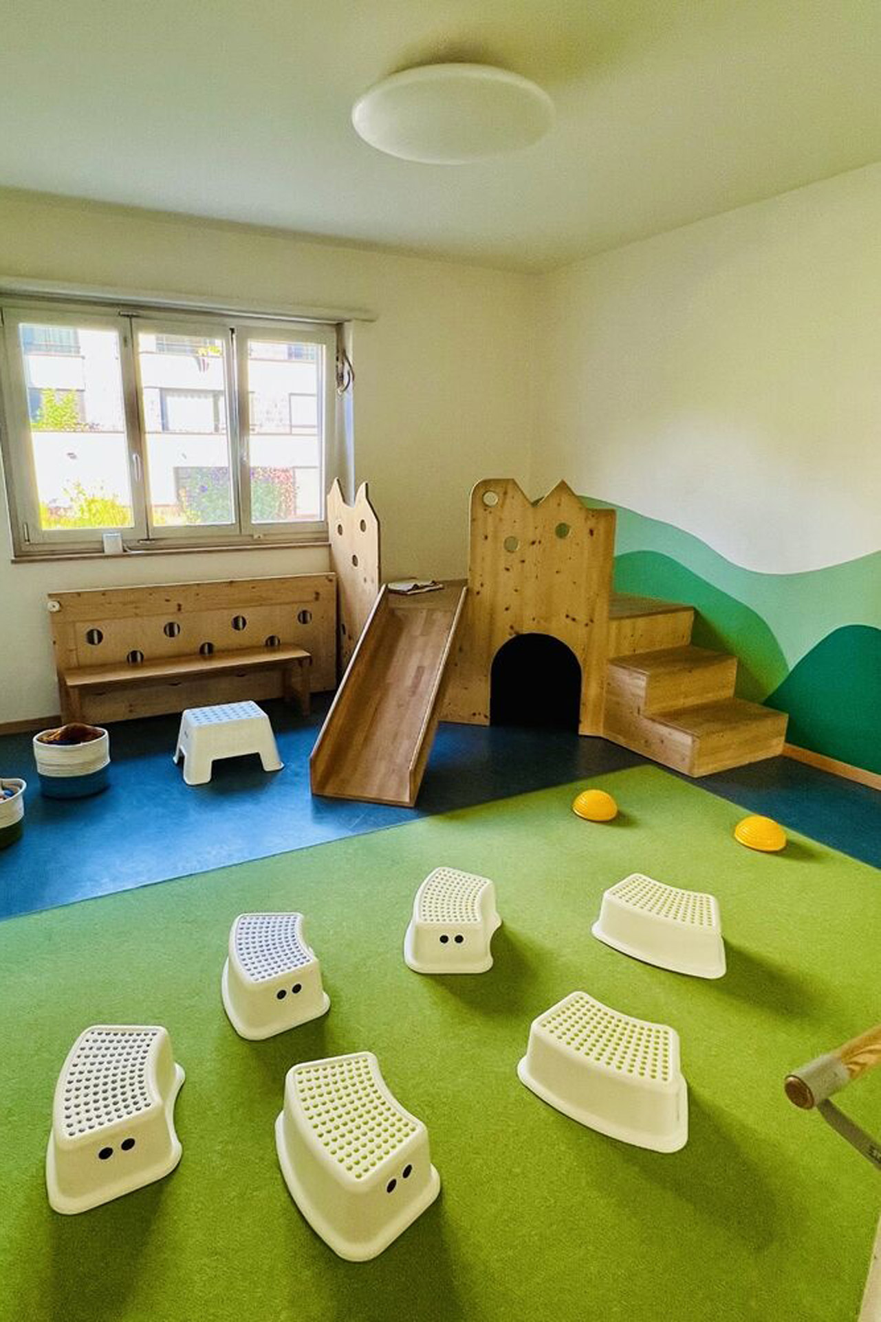 Kita kidsco Kreuzwiesen Kitaraum mit Holzrutsche und Sitzmöbel